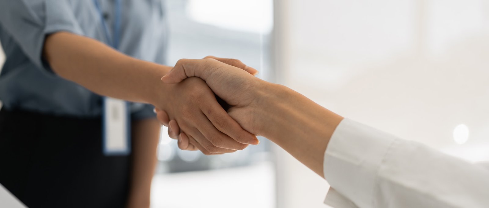 Close up view of businessmen hands shaking in conference room